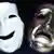 A white smiling mask next to a gray frowning mask.