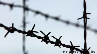 Stacheldrahtzaun im Konzentrationslager Dachau: Am 21. März 1933 gab Heinrich Himmler die Errichtung eines Konzentrationslagers in Dachau in Auftrag. Damit begann in Dachau ein Terrorsystem, das mit keinem anderen staatlichen Verfolgungs- und Strafsystem verglichen werden kann. Die ersten Häftlinge waren politische Gegner des Regimes, Kommunisten, Sozialdemokraten, Gewerkschafter, vereinzelt auch Mitglieder konservativer und liberaler Parteien. Auch die ersten jüdischen Häftlinge wurden auf Grund ihrer politischen Gegnerschaft in das Konzentrationslager Dachau eingeliefert. In den folgenden Jahren wurden immer neue Gruppen nach Dachau verschleppt: Juden, Homosexuelle, Zigeuner, Zeugen Jehovas, Geistliche u.a. Allein als Folge des Novemberpogroms, der sogenannten Reichskristallnacht, wurden mehr als 10.000 Juden in das Konzentrationslager Dachau gebracht. Insgesamt waren über 200.000 Häftlinge aus mehr als 30 Staaten in Dachau inhaftiert. (Foto vom 25.10.2002)