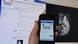 A hand holding a smart phone showing the Facebook page of the Hesse state police A hand holding a smart phone showing the Facebook page of the Hesse state police