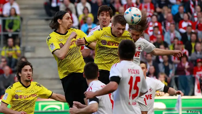 Borussia Dortmund's Lukasz Piszczek (C) scores a goal against Cologne during the German first division Bundesliga soccer match in Cologne March 25, 2012. REUTERS/Ina Fassbender (GERMANY - Tags: SPORT SOCCER) DFL LIMITS USE OF IMAGES ON THE INTERNET TO 15 PICTURES DURING THE MATCH AND, PROHIBITS MOBILE (MMS) USE DURING AND UP TO 2 HOURS POST MATCH. FOR MORE INFORMATION CONTACT DFL