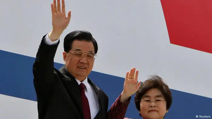 China's President Hu Jintao (L) and his wife Liu Yongqing wave upon their arrival at the airport in New Delhi March 28, 2012. Hu is in India to attend the BRICS (Brazil, Russia, India, China and South Africa) Summit in India on Thursday. REUTERS/B Mathur (INDIA - Tags: POLITICS)