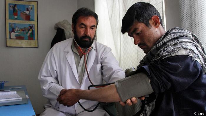 Afghan doctor Mohammad Daoud Aslami checks the pressure of a patient at a health center in Kabul, Afghanistan (ddp images/AP Photo/Musadeq Sadeq)