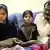 Ashiq Masih, der Ehemann von Asia Bibi gemeinsam mit zwei Töchtern auf einem Sofa (Foto: picture alliance/dpa)