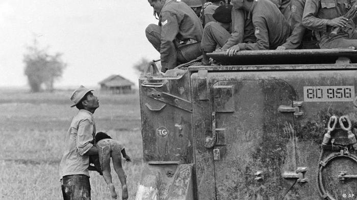 1964: Ein Vater hält Soldaten sein bei Kämfen getötes Kind entgegen (Archivfoto: AP/Horst Faas)