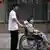In this photo taken on June 30, 2010, Ni Yulan on a wheelchair is helped by her husband Dong Jiqin outside a temporary lodging in a hotel in Beijing. Ni, a former lawyer and veteran activist left disabled by past police mistreatment, went on trial Thursday, Dec. 29, 2011, the third dissident in a week to be prosecuted as China presses a sweeping crackdown to deter popular uprisings like the ones that shook the Arab world. (AP Photo/Andy Wong)