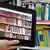 Electronic tablet device showing books on shelves. In the background the shelves loaded with books