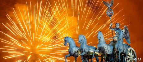 Fireworks light the sky above the Quadriga at the Brandenburg Gate in Berlin shortly after midnight, greeting the New Year, Sunday, Jan. 1, 2012. Hundred thousands of people celebrated the beginning of the New Year 2012 in Germany's capital. (AP Photo/Michael Sohn)