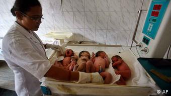 An Indian nurse observes newly born babies at a hospital
