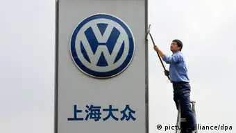 ARCHIV - Ein Arbeiter reinigt das Firmenschild eines Volkswagen Autohauses in der Nähe von Shanghai (Archivfoto vom 13.10.2005). Der Volkswagenkonzern will sich künftig stärker auf die wohlhabenden Boomregionen im Süden Chinas konzentrieren. Bis 2018 wollen die Wolfsburger ihren Absatz in den Küstenprovinzen im Südosten von gegenwärtig 150 000 auf eine halbe Million mehr als verdreifachen, wie der China-Chef von Volkswagen, Winfried Vahland, am Montag 23.11.2009 auf der Automesse in der südchinesischen Metropole Kanton sagte. Foto: Gero Breloer dpa/lnw +++(c) dpa - Bildfunk+++ Verwendung nur in Deutschland, usage Germany only