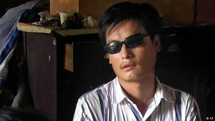 FILE - In this undated file photo released by his supporters, blind activist Chen Guangcheng, right sits in a village in China. Rights activists have criticized a Hollywood studio for filming a buddy comedy in an eastern Chinese city where the blind, self-taught activist lawyer is being held under house arrest and reportedly beaten. Relativity Media is shooting part of the comedy 21 and Over in Linyi, a city in Shandong province where the activist Chen's village is located. Authorities have turned Chen's village of Dongshigu into a hostile, no-go zone and activists, foreign diplomats and reporters have been turned back, threatened and had stones thrown at them by men patrolling the village. (AP Photo/Supporters of Chen Guangcheng, File)