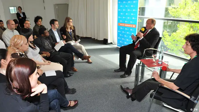 Dirk Niebel diskutiert mit Volontären und Studenten der International Media Studies bei der DW Akademie in Bonn (Foto: DW).