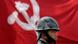 A Nepali policeman stands guard against the flag of the Communist party of Nepal (Maoist) A Nepali policeman stands guard against the flag of the Communist party of Nepal (Maoist)