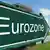 Symbolic signpost in green, displaying the word "Eurozone."