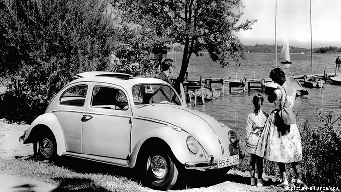 A family with a VW at a lake (Photo: picture-alliance/dpa)