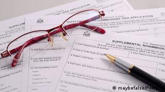 Очки и ручка лежат на анкете для получения американской визы