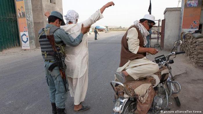 Ein afghanischer Polizist bei der Kontrollen von Personen an einem Checkpoint (Foto: DPA)