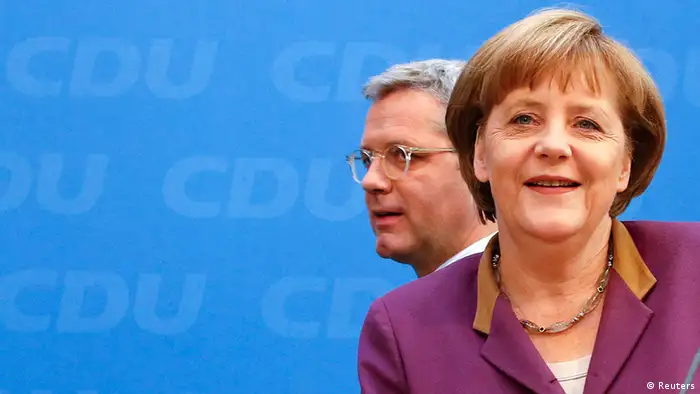 Christian Democratic Union (CDU) party leader and Chancellor Angela Merkel (L) and Environment Minister Norbert Roettgen arrive to address a news conference in Berlin, May 14, 2012. Chancellor Angela Merkel's conservatives suffered a crushing defeat on Sunday in an election in Germany's most populous state, a result which could embolden the left opposition to step up its criticism of her European austerity policies. REUTERS/Fabrizio Bensch (GERMANY - Tags: POLITICS)