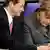 German Chancellor Angela Merkel and Foreign Minister Guido Westerwelle look at a smartphone in parliament.