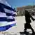 A Greek flag waves at Syntagma square in front of the Greek Parliament