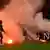 Die Herthaner Spieler räumen im Relegationsspiel in Düsseldorf bengalische Feuer ihrer Fans vom Rasen. (Foto: dpa)