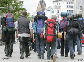 Teilnehmer gehen in einer Stadt mit Rucksäcken auf dem Rücken (AP Photo/Jens Meyer)