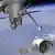 Computerillustration der NASA zeigt eine unbemannte «Dragon»-Kapsel, die vom Roboterarm der ISS gepackt und in die richtige «Parkposition» gebracht wird. Foto: dpa
