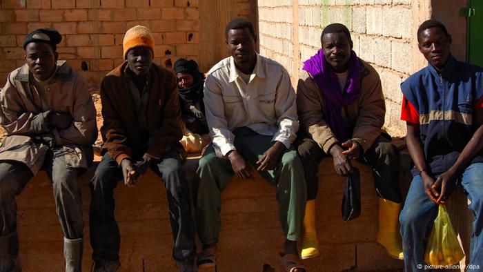 Arbeitslose afrikanische Männer sitzen auf einer Mauer in Germa, Libyen (Foto: dpa)