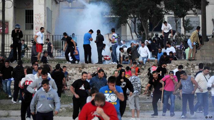 Ausschreitungen in Patras: Demonstranten, im Hintergrund Rauch (Foto: AP)