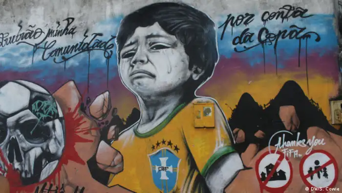 Mural showing a crying boy in a Brazilian jersey and a football resembling a skull next to the words thank you Fifa