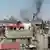 Image purports to show black smoke rising from buildings in Homs, Syria.