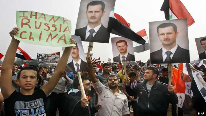 Syrian regime supporters hold up Bashar Assad's portrait and a man holds up a banner that reads Thank China and Russia during a rally in Umayyad Square in downtown Damascus, Syria, Wednesday Oct. 26, 2011. Tens of thousands of Syrians packed a Damascus square Wednesday in a show of support for embattled President Bashar Assad, a few hours ahead of a visit by senior Arab officials probing ways to start a dialogue between the regime and the opposition. (ddp images/AP Photo/Muzaffar Salman)