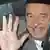 Former French President Jacques Chirac waves from inside a car