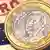 A Spanish euro coin atop a euro bill and an EU flag