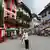 Ein Baurabeiter läuft mit einer Leiter durch das österreichisch anmutende Luxusviertel in Huizhou.
