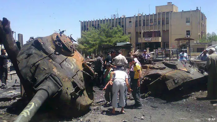 In this citizen journalism image provided by Edlib News Network ENN, anti-Syrian regime citizens look at a Syrian tank that was damaged during clashes between rebels and Syrian government forces, at the northern town of Ariha , in Idlib province, Syria, Monday, June 4, 2012. European leaders are expected to press the contentious issue of Syria at a European Union-Russian summit Monday in St. Petersburg, but few believe Russian President Vladimir Putin will agree to ramp up pressure on the Syrian government. (Foto:Edlib News Network ENN/AP/dapd) THE ASSOCIATED PRESS IS UNABLE TO INDEPENDENTLY VERIFY THE AUTHENTICITY, CONTENT, LOCATION OR DATE OF THIS HANDOUT PHOTO