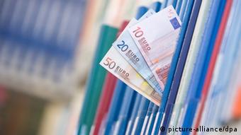 Euro bills between folders, Copyright: Friso Gentsch dpa/lni