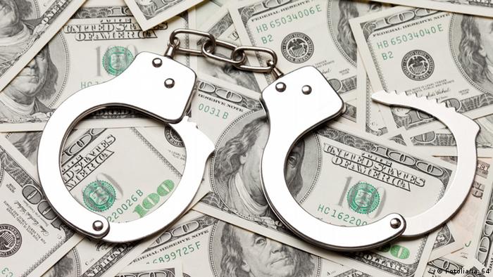 Symbolbild Korruption Handschellen auf US Dollar
