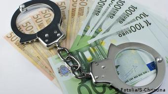 Close-up handcuffs and money over white background.