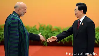 epa03252237 Chinese President Hu Jintao (R) greets Afghanistan President Hamid Karzai at the Shanghai Cooperation Organization (SCO) summit in the Great Hall of the People in Beijing, China, 07 June 2012. Security in Central Asia, including the situation in Afghanistan, is set to be the focus of talks at a meeting in Beijing of a regional group dominated by China and Russia. EPA/MARK RALSTON / POOL +++(c) dpa - Bildfunk+++