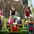 Erzieherinnen mit kleinen Kindern, die in Spiel-Kinderwagen sitzen Foto: dpa