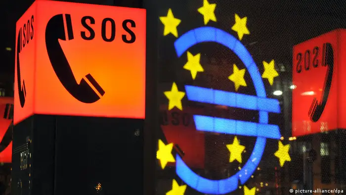 ARCHIV - SOS-Zeichen an einer Notrufsäule umrahmen am 21.12.2011 das Euro-Zeichen vor der Europäischen Zentralbank (EZB) in Frankfurt am Main. Spanien rutscht immer tiefer in die Krise. Für einen neuen Tiefschlag sorgte am Donnerstagabend die Ratingagentur Fitch. Sie senkte die Kreditwürdigkeit des Landes um drei Stufen herab. Spanien ist von einer massiven Bankenkrise gebeutelt, steckt in einer schweren Rezession und kämpft mit einem zu hohen Staatsdefizit. Foto: Boris Roessler dpa (zu dpa «Spanien rutscht immer tiefer in die Krise» vom 08.06.2012) +++(c) dpa - Bildfunk+++