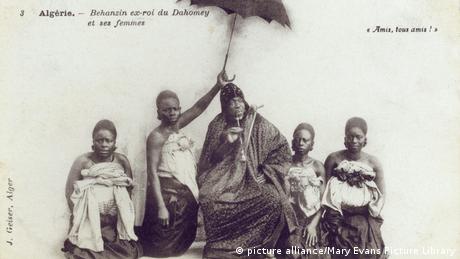 King Behanzin and his four wives; one of them is holding an umbrella.