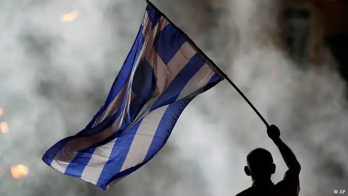 An elderly supporter of New Democracy party waves a Greek flag in front of a smoke from flairs during an election rally at Syntagma square in Athens, Friday, June 15, 2012. Greeks cast their ballots this Sunday for the second time in six weeks, after May 6 elections left no party with enough seats in Parliament to form a government and coalition talks collapsed. (Foto:Petros Karadjias/AP/dapd)