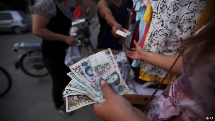 A Chinese woman, who sells clothes on the roadside, holds tens of Yuan, while dealing with a customer, in a Hutong, or a traditional alleyway, in Beijing, China, Tuesday, June, 22, 2010. Proving that flexibility is a two-way street, the Chinese yuan edged lower against the U.S. dollar in spot trading Tuesday, a day after surging to a new high following the central bank's decision to let the currency trade in a wider range. (ddp images/AP Photo/Muhammed Muheisen)