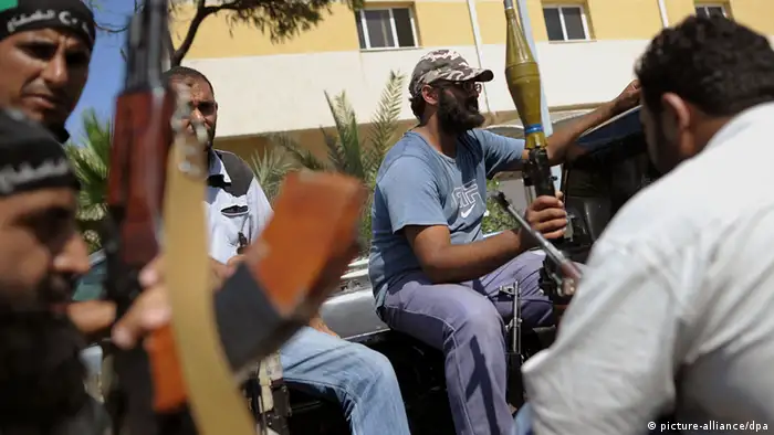 Rebellen sitzen am Mittwoch (24.08.2011) auf einem Stützpunkt in Tripolis auf einem Pickup und warten auf einen Einsatz. Das Regime des libyschen Diktators Gaddafi ist am Ende, doch trotz der Siegesfeiern der Rebellen kämpfen seine letzten Getreuen erbittert gegen den Untergang. In Tripolis und anderen Orten Libyens lieferten sich Aufständische und Gaddafis Truppen am Mittwoch weiterhin teils schwere Gefechte. Foto: Hannibal dpa/lbn pixel