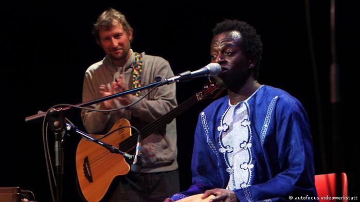 Zwei Mitglieder der Band The Refugees während eines Konzerts.