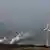 Windräder drehen sich unweit des Vattelfall- Braunkohlekraftwerkes im brandenburgischen Jänschwalde vor den Kühltürmen (Foto: dpa9