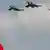 Turkish Air Force fighters fly over a national flag