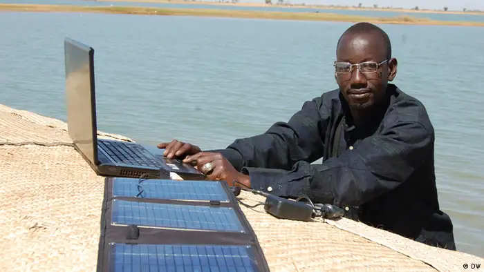 Boukary Konaté en route avec son ordinateur le long du fleuve