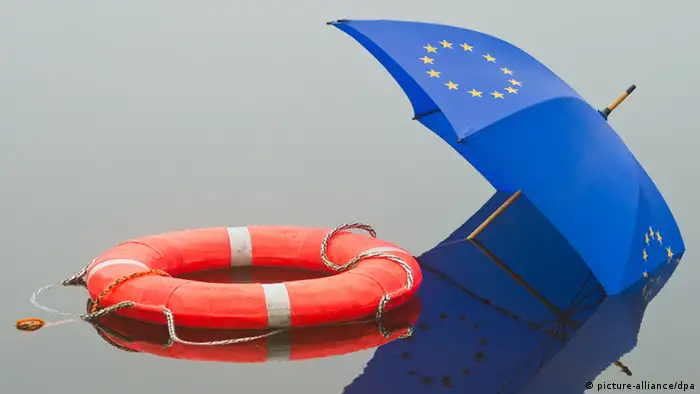 Ein Regenschirm mit EU-Sternen liegt neben einem Rettungsring im Wasser eines Sees in Frankfurt (Oder) (Illustration zum Thema: Rettungsschirm), aufgenommen am 09.11.2011. Foto: Patrick Pleul